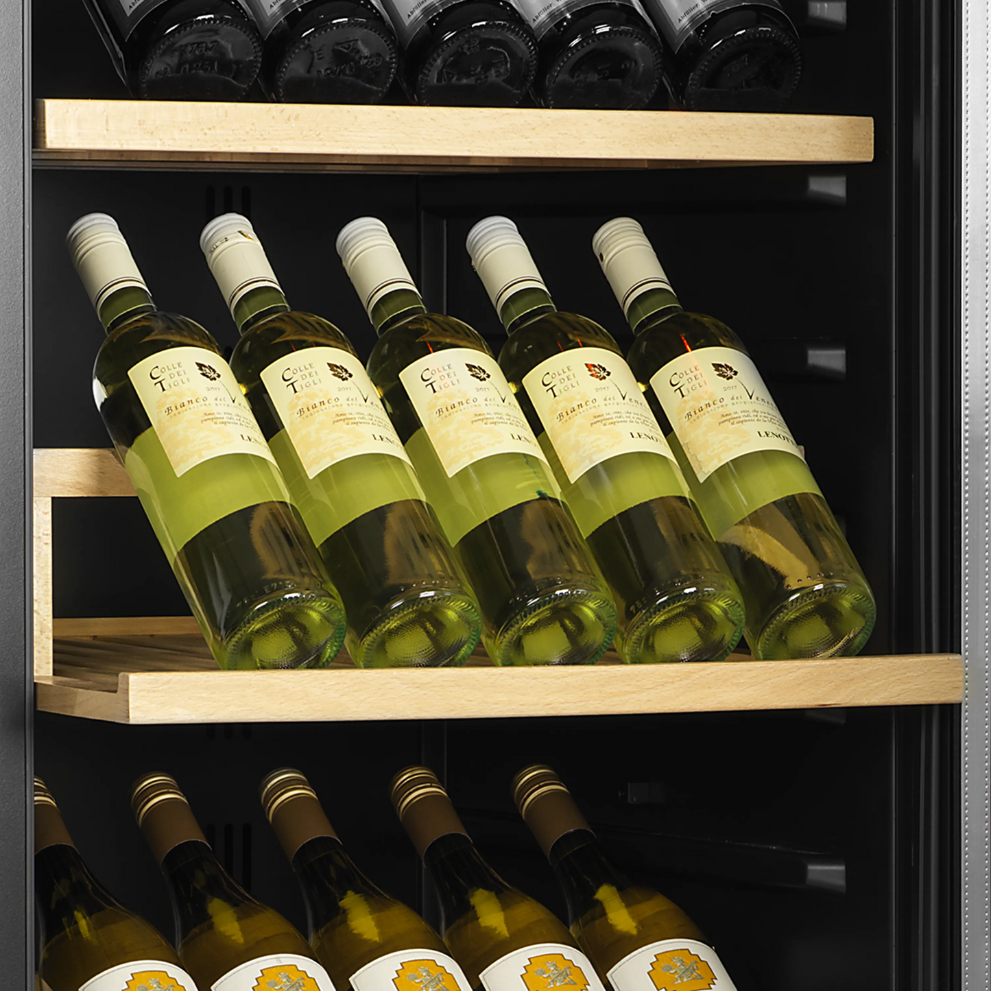 Sleek dual-zone wine cabinet with glass door, showcasing bottles on wooden shelves.